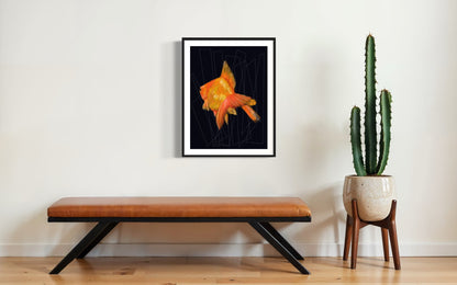 Cuadro de pez dorado con fondo negro y geometría sutil en pared blanca junto a cactus. 
